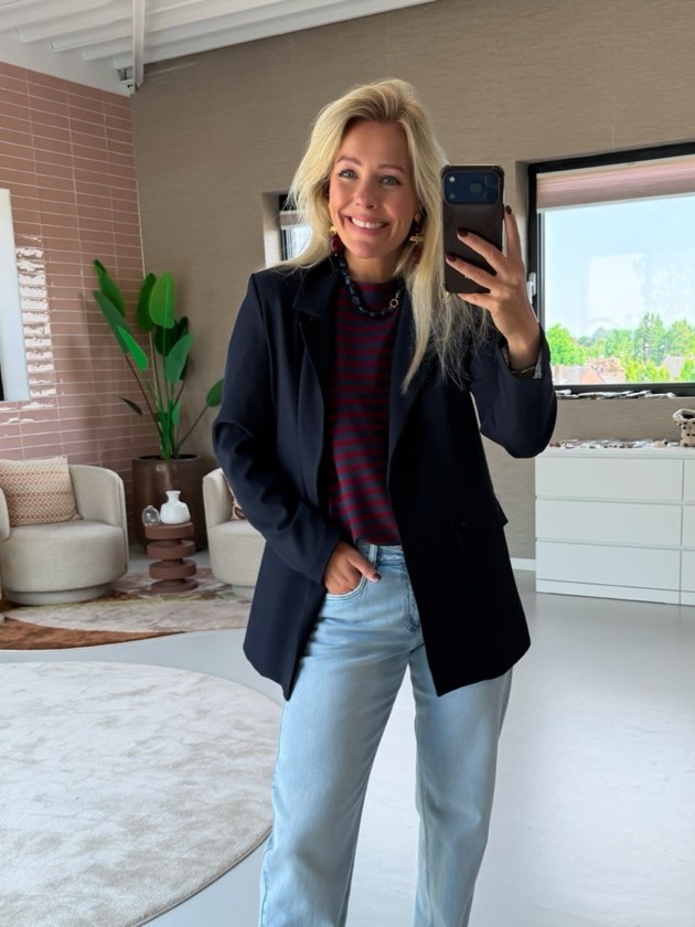 Willemijn in navy blazer en lichte jeans, spiegelselfie in de winkel