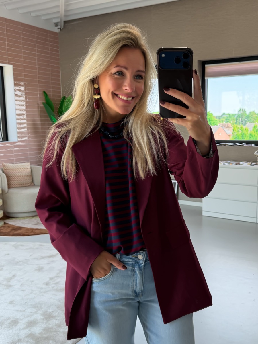 Willemijn in een bordeaux blazer over een gestreept shirt, spiegelselfie