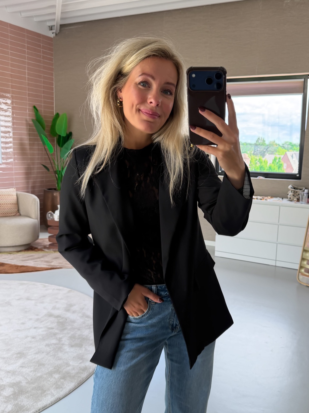 Willemijn in de Dawn oversized blazer zwart over een kanten topje, spiegelselfie met telefoon in beeld
